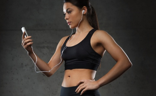 Woman in active gear listening to music on her phone